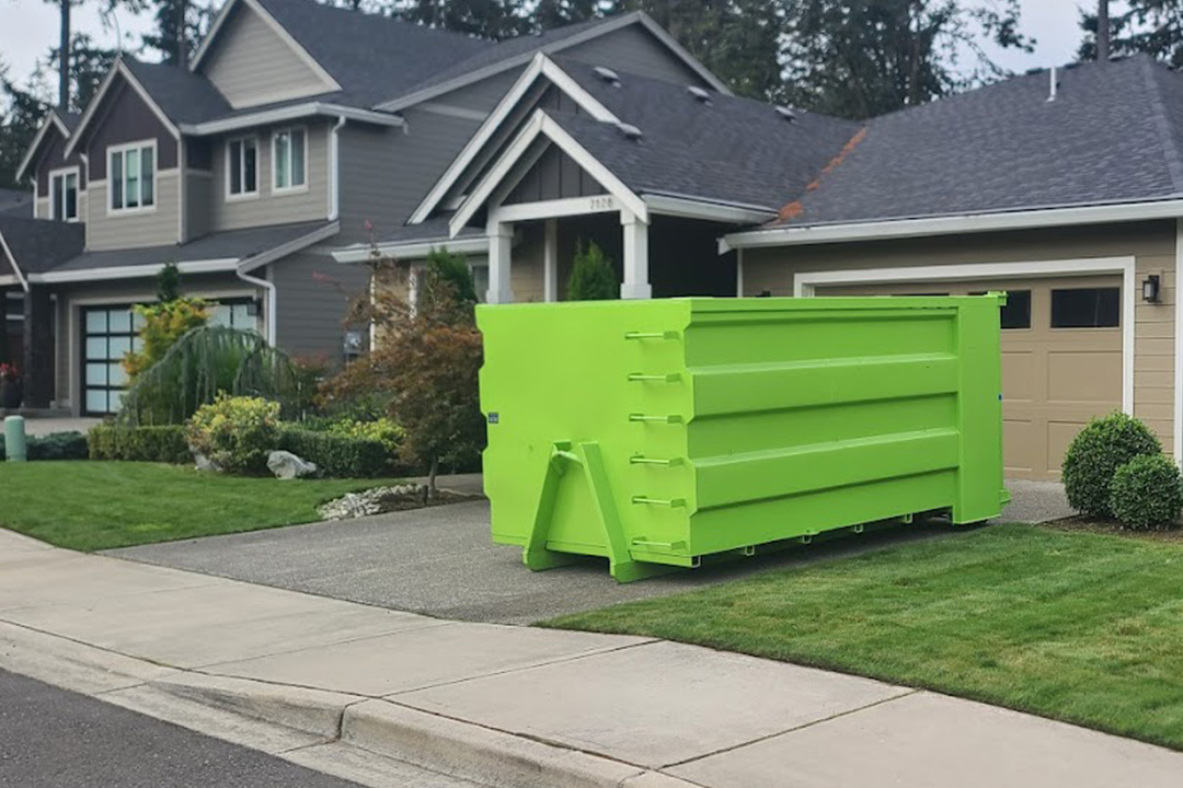 rolloff dumpster rental in driveway in front of house