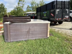 hot tub in grass about to be removed by Haul n All Junk Removal